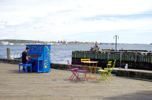 Person playing piano by the waterfront