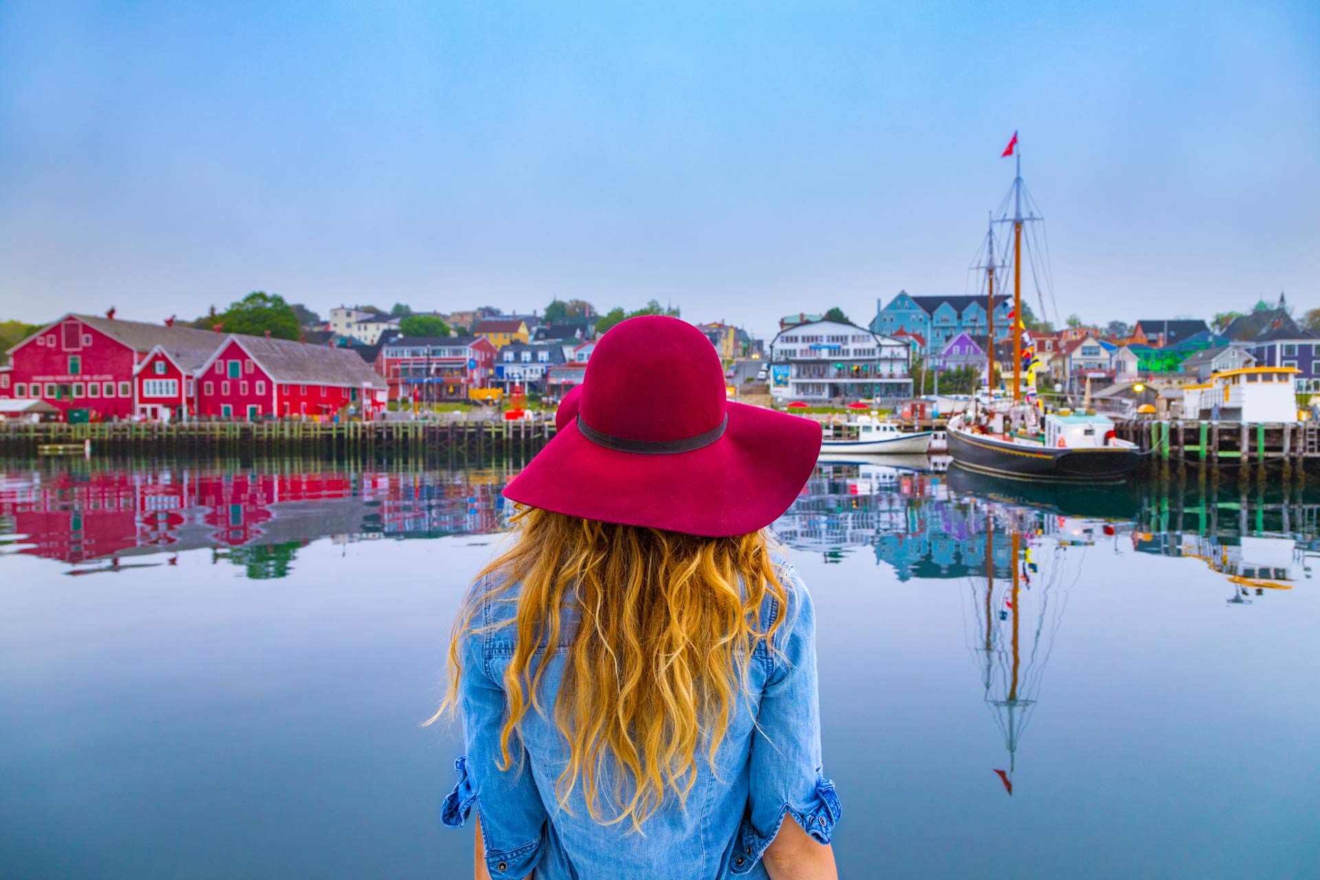 Woman wearing hat watching out at waterfront