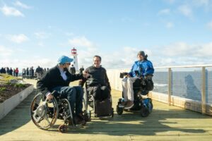 People in wheelchairs on an accessible boardwalk at Peggys Cove
